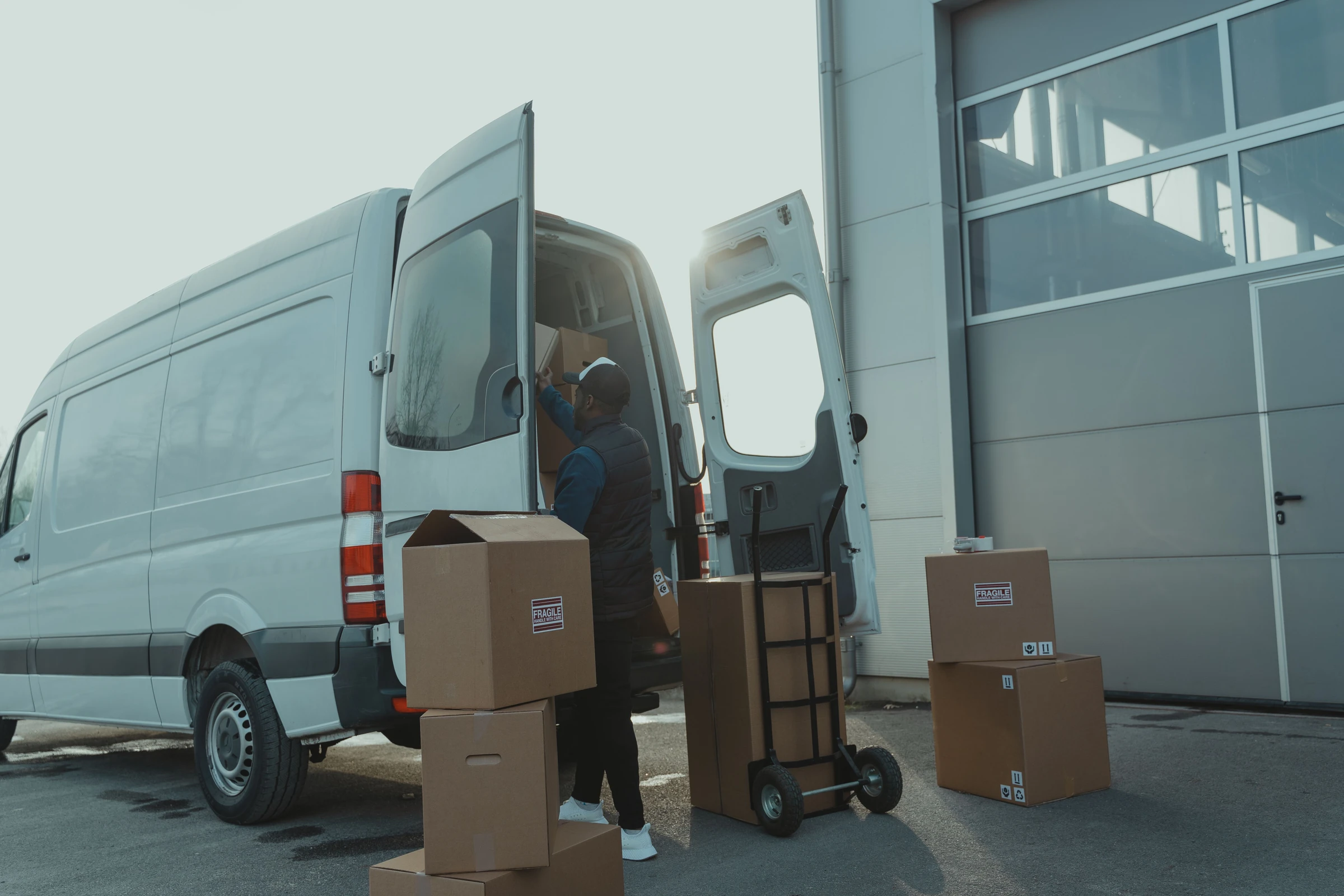 Courier loading parcels into a delivery vehicle