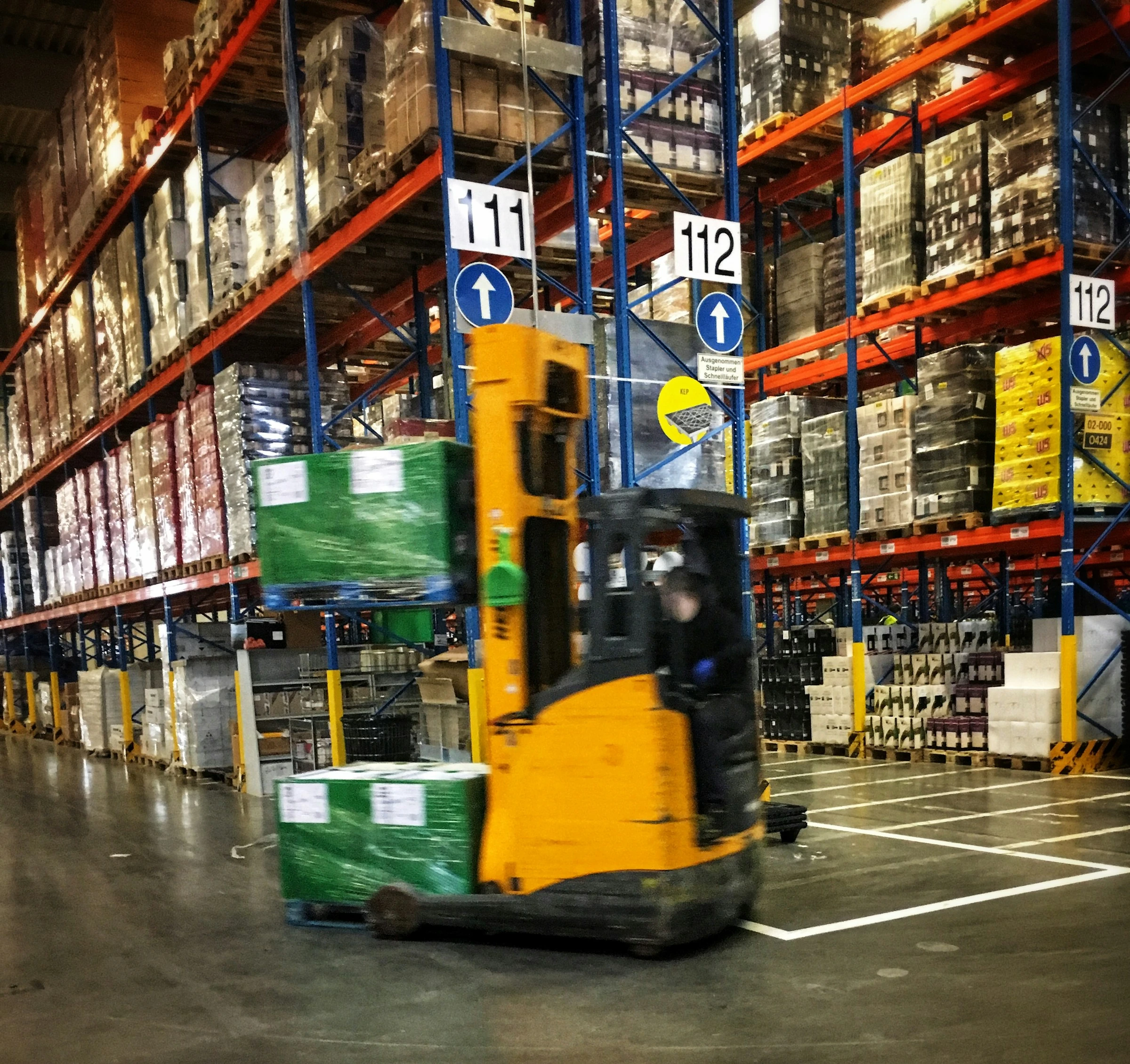 Forklift operating inside a stocked pallet warehouse